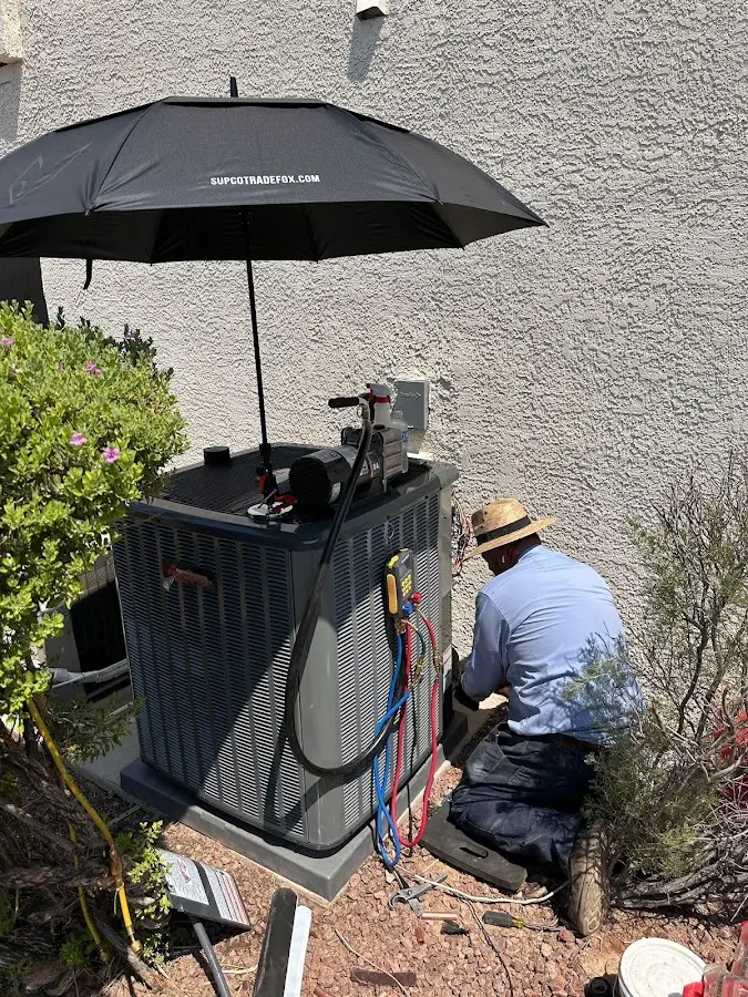 HVAC technician performing outdoor AC maintenance in George Mason